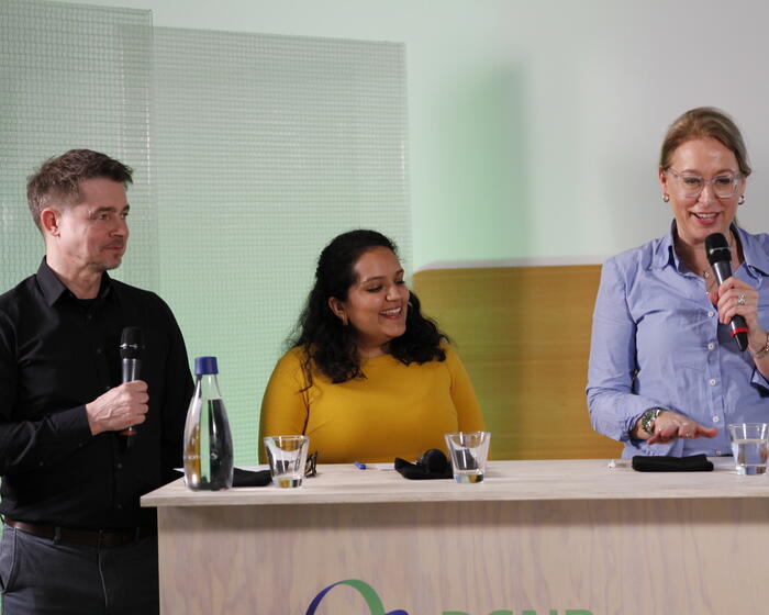Auf dem Bild sind Matthias Schäpers, Seema Issar und Dr. Christine Lemaitre (alle drei von der DGNB) hinter einem Podium zu sehen. Christine Lemaitre hält ein Mikrofon in der Hand.